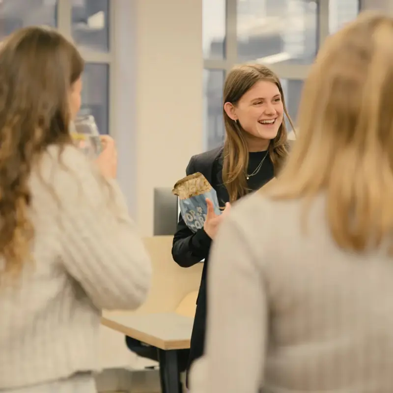 Team members chatting and laughing over a drink in the studio